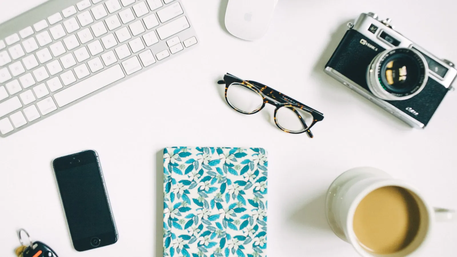A camera and eyeglasses on a creative workspace